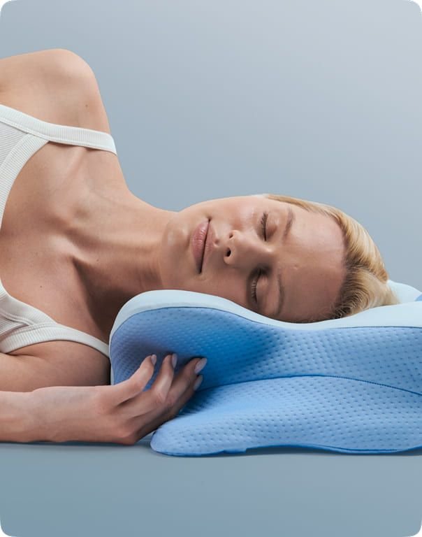 Woman sleeping on her side with her face resting against the Derila Ergo pillow cover